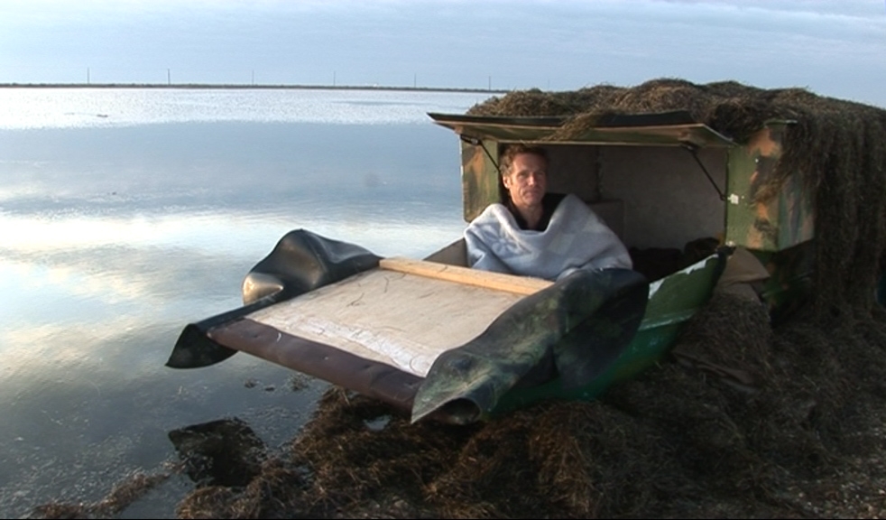 Le réalisateur Philippe Lespinasse dans une cabane à oiseau près d'un étang