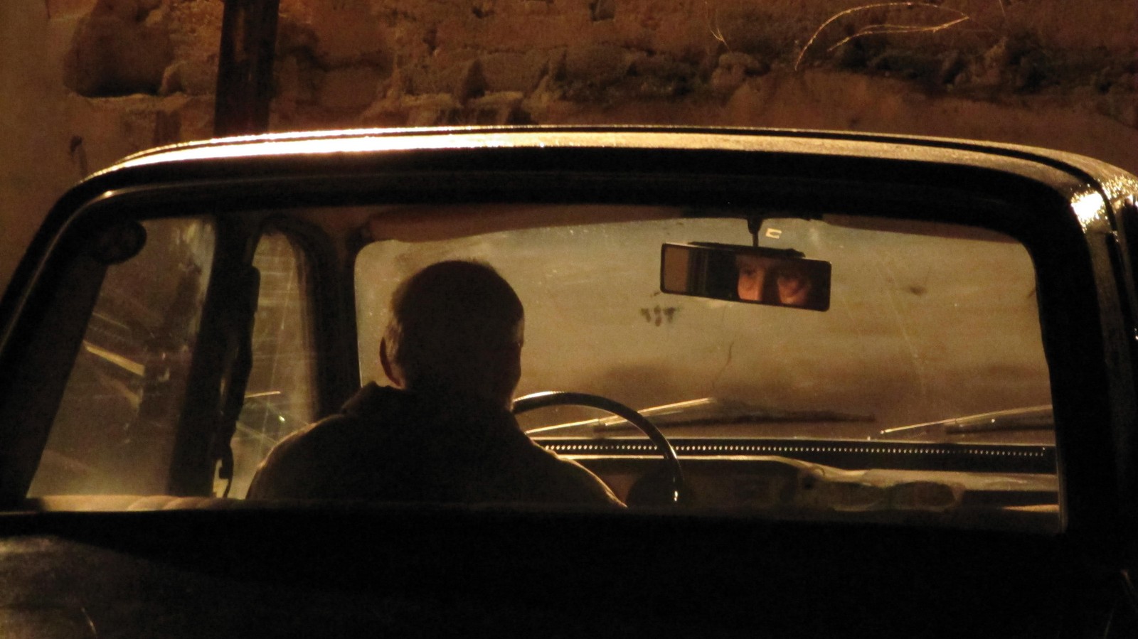 //www.occitanie-films.netUn homme est assis dans une voiture, seul, il regarde au loin