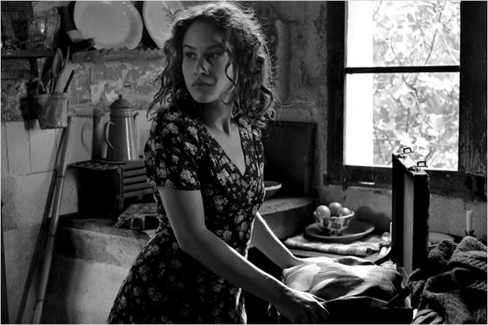 //www.occitanie-films.netUne jeune femme est debout dans une cuisine, devant une fenêtre, elle regarde derrière elle