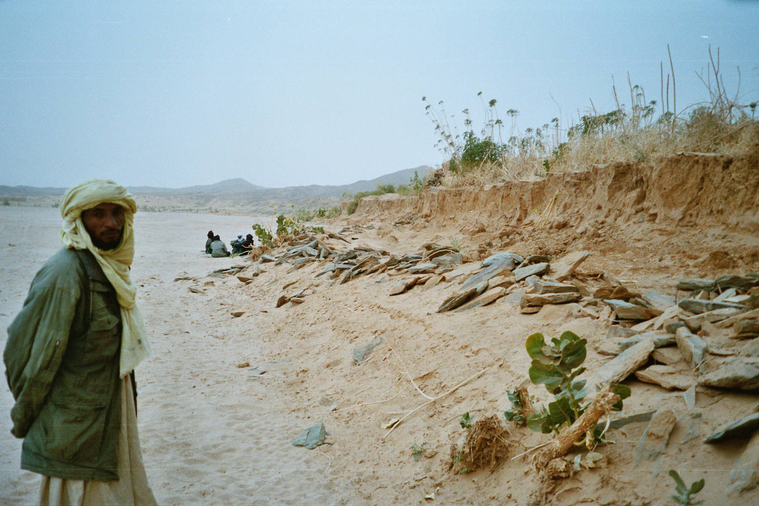Homme Touareg face à un rivage creusé par la mer et les pluies diluviennes de l'Oued