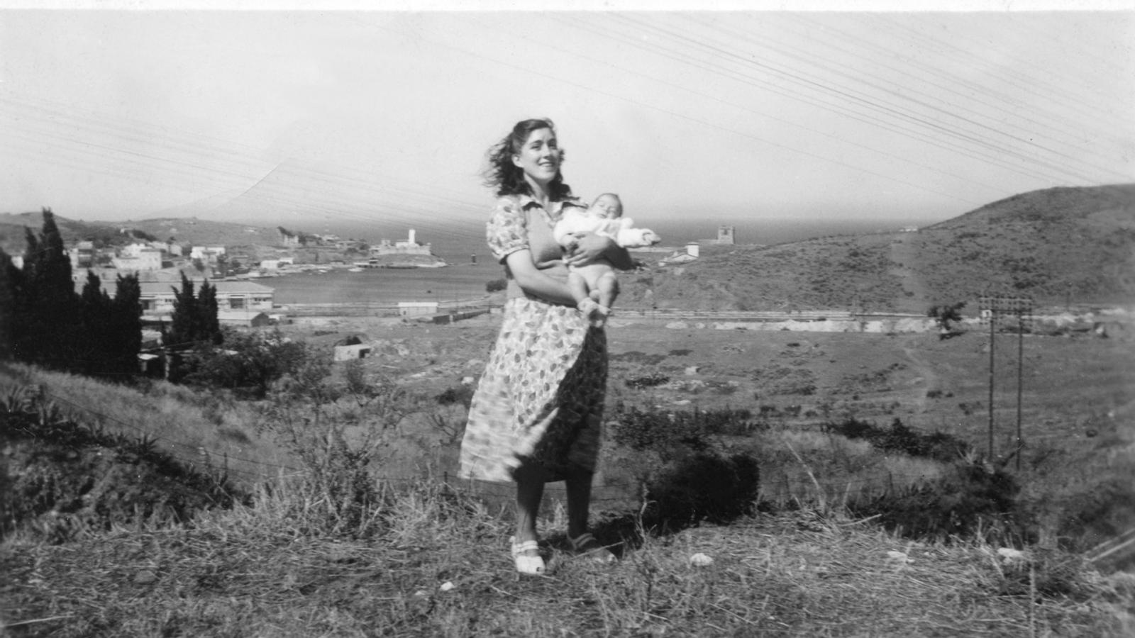 Photo en noir et blanc d'une mère portant un bébé dans ses bras, sur une colline de Port-Vendres