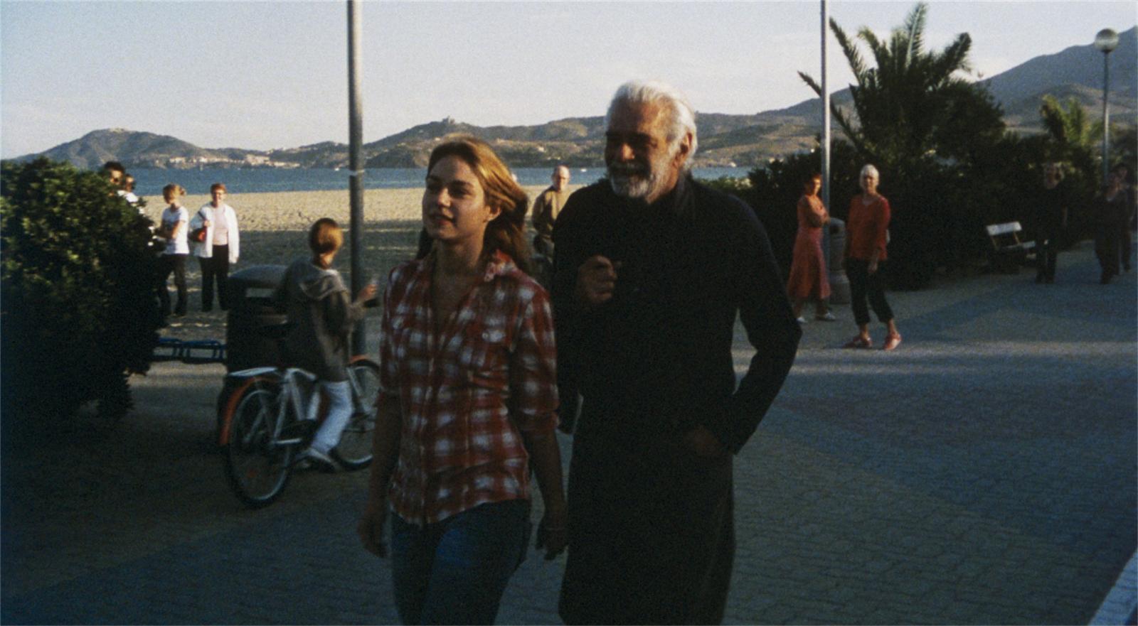//www.occitanie-films.netUn homme d'âge mur et une jeune fille marchent sur une promenade