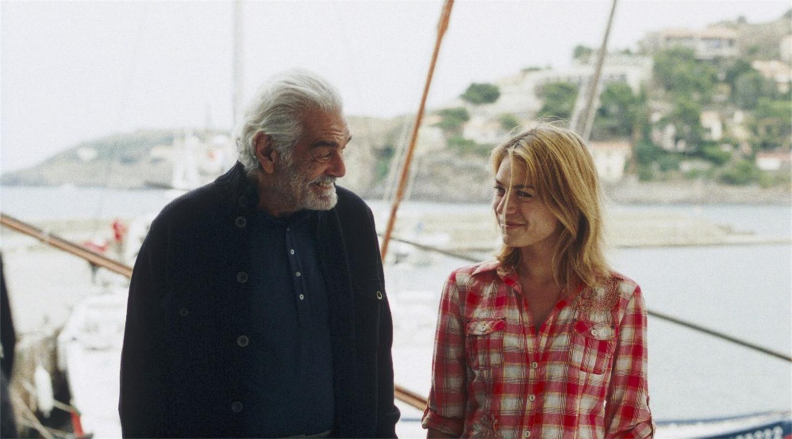 //www.occitanie-films.netUn homme d'âge mur et une jeune fille se regardent avec complicité, devant un bateau