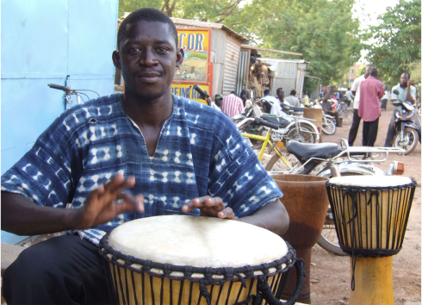 Jules César, artisan fabriquant de djembé, jouant du djembé