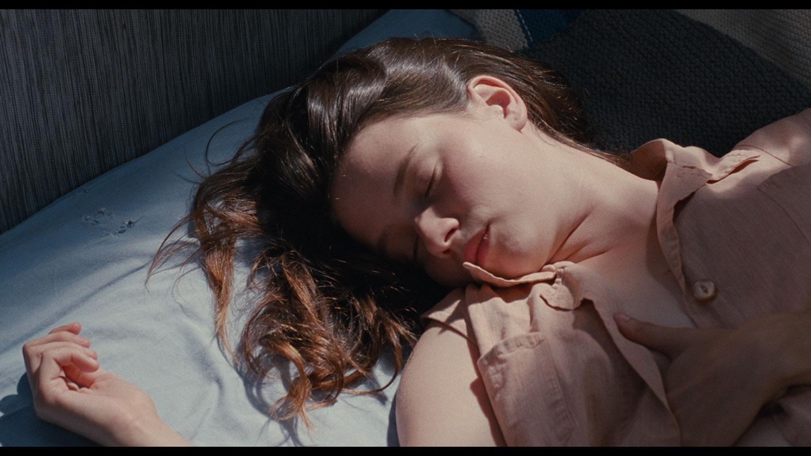 //www.occitanie-films.netJeune fille assoupie sur un lit au drap blanc