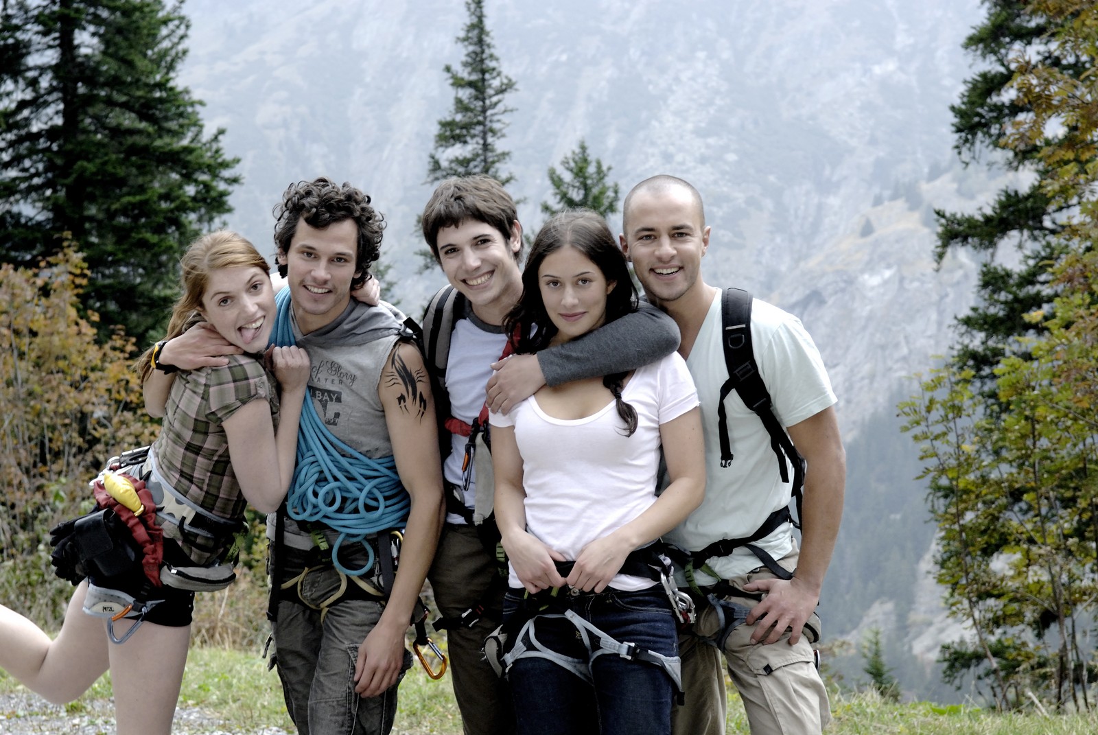 Cinq amis randonneurs posent devant une montagne