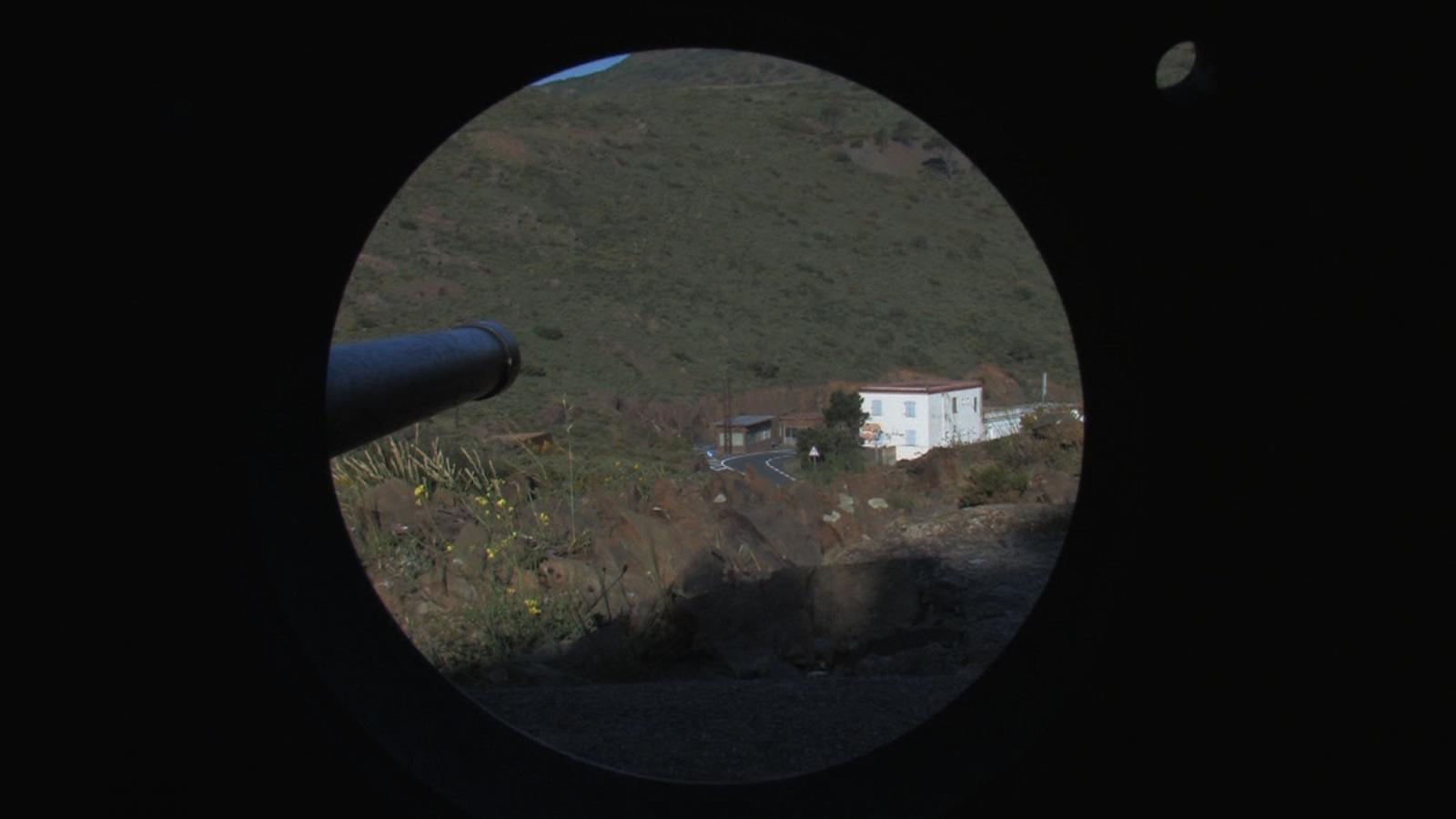 //www.occitanie-films.netFish eye : point de vue du viseur d'un fusil, qui pointe une maison au loin